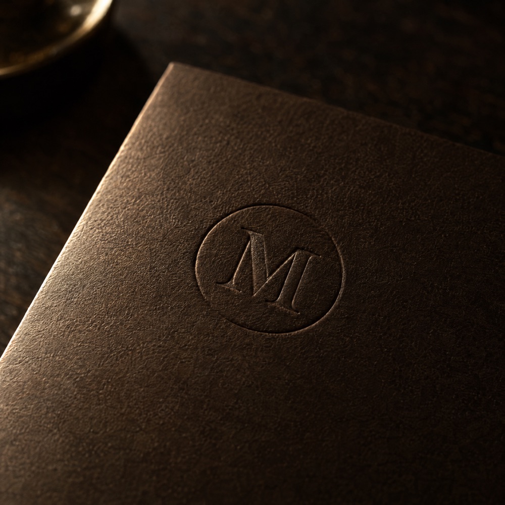Geprägtes Monogramm auf einer dunklen Menükarte